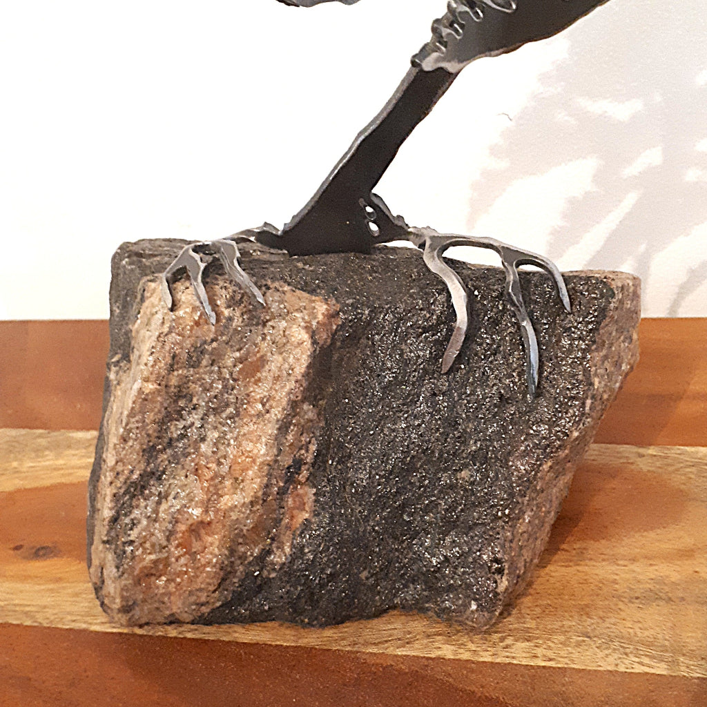 detail of rock with metal roots of a tree sculpture