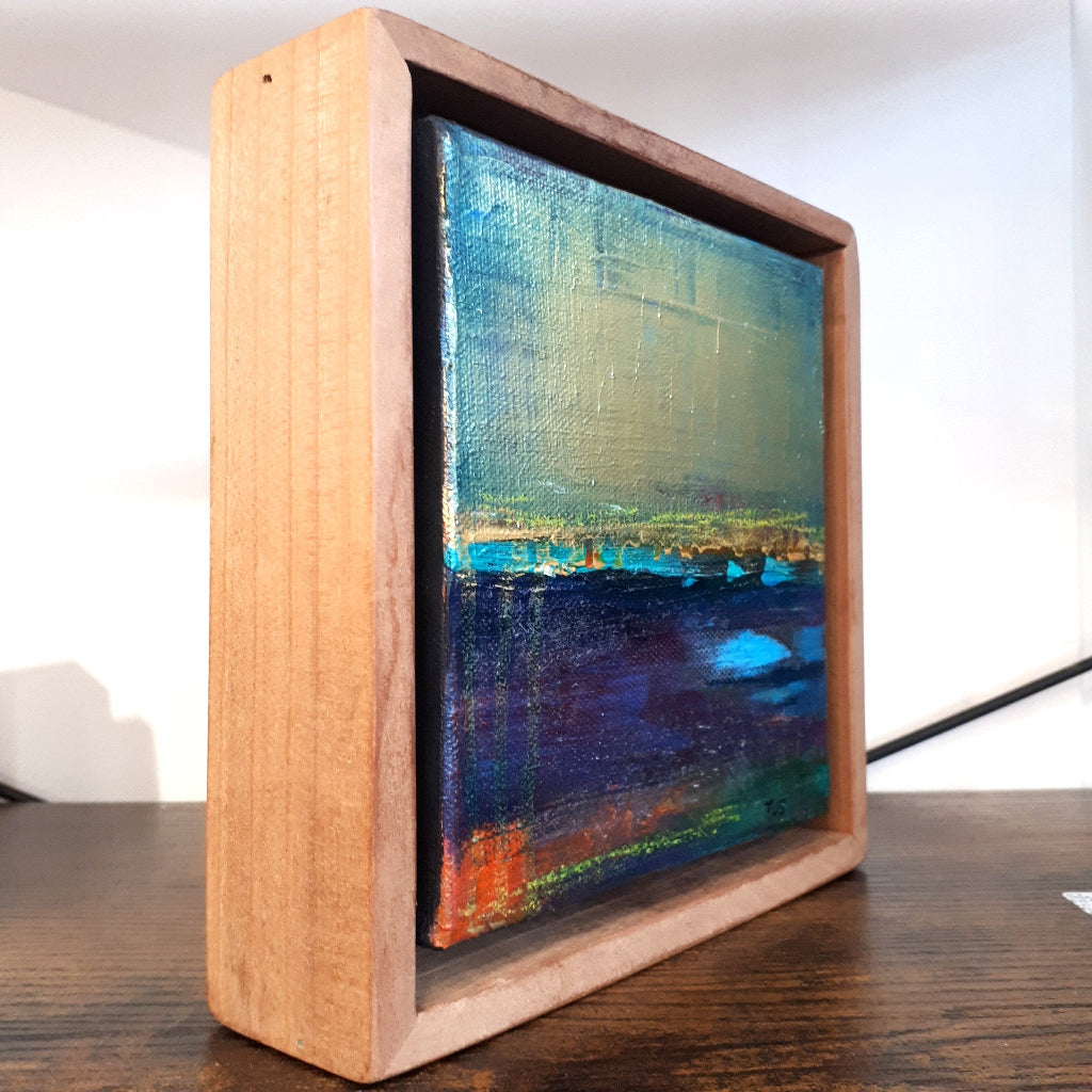 Wood float frame on artwork with a colorful abstract design on canvas
